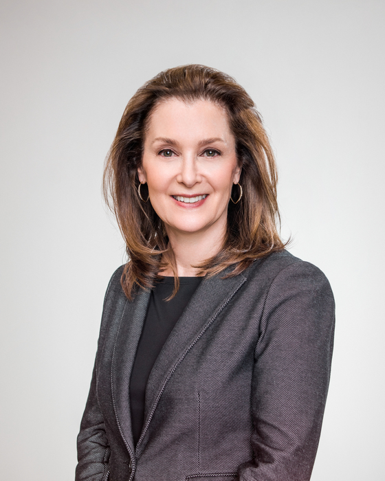 Headshot for ESRB president PAtricia Vance. She is seen standing in a grey void in professional dress smiling warmly.