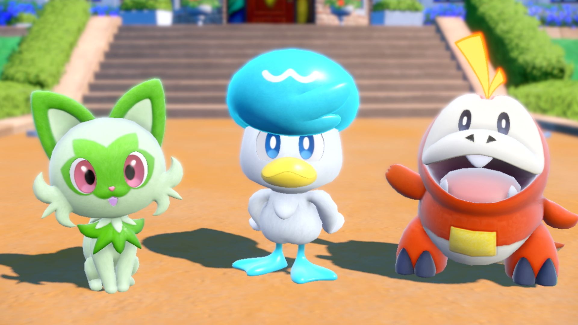 A picture of the three starter Pokémon in Pokémon Scarlet and Violet. In order from left to right, Sprigatito (a leafy green kitten), Quaxly (a blue duck), and Fuecoco (a small fiery alligator)