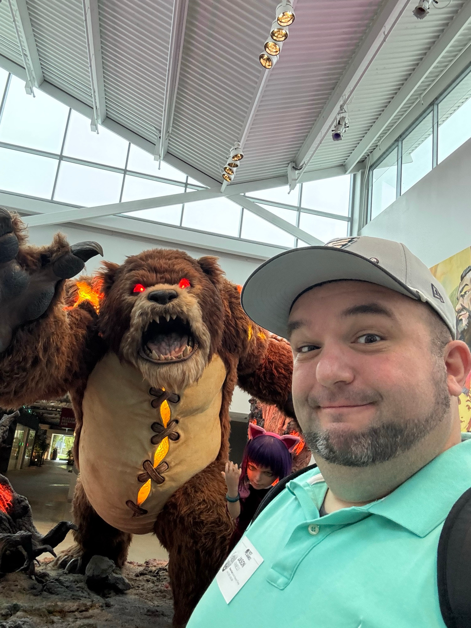 A headshot of Jason Fanelli standing in front of a bear monster with red eyes.