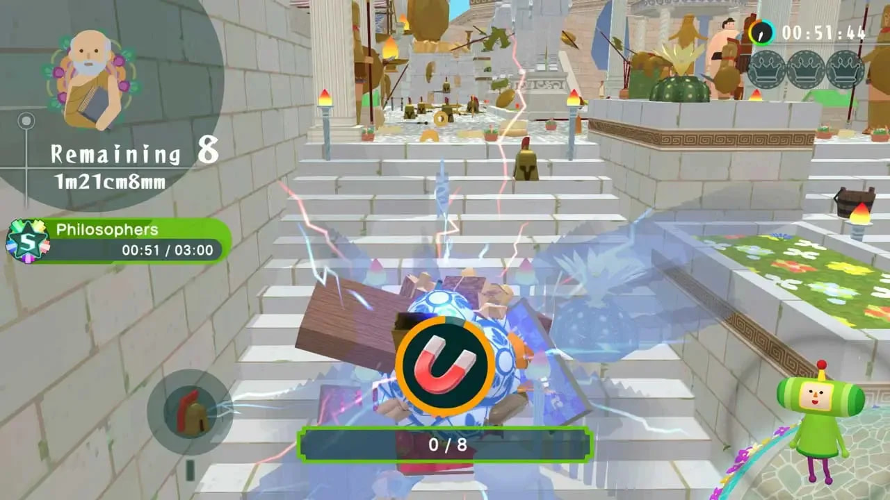 The Prince pushes a Katamari through the narrow, stone roads of Ancient Greece. With a magnet power up equipped, the Prince is attracting various Greek-themed items, such as pottery.