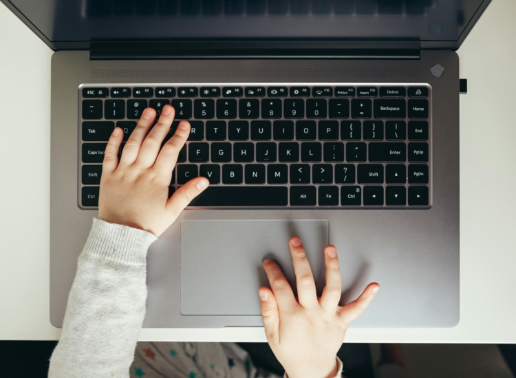 Child's hands on laptop keyboard