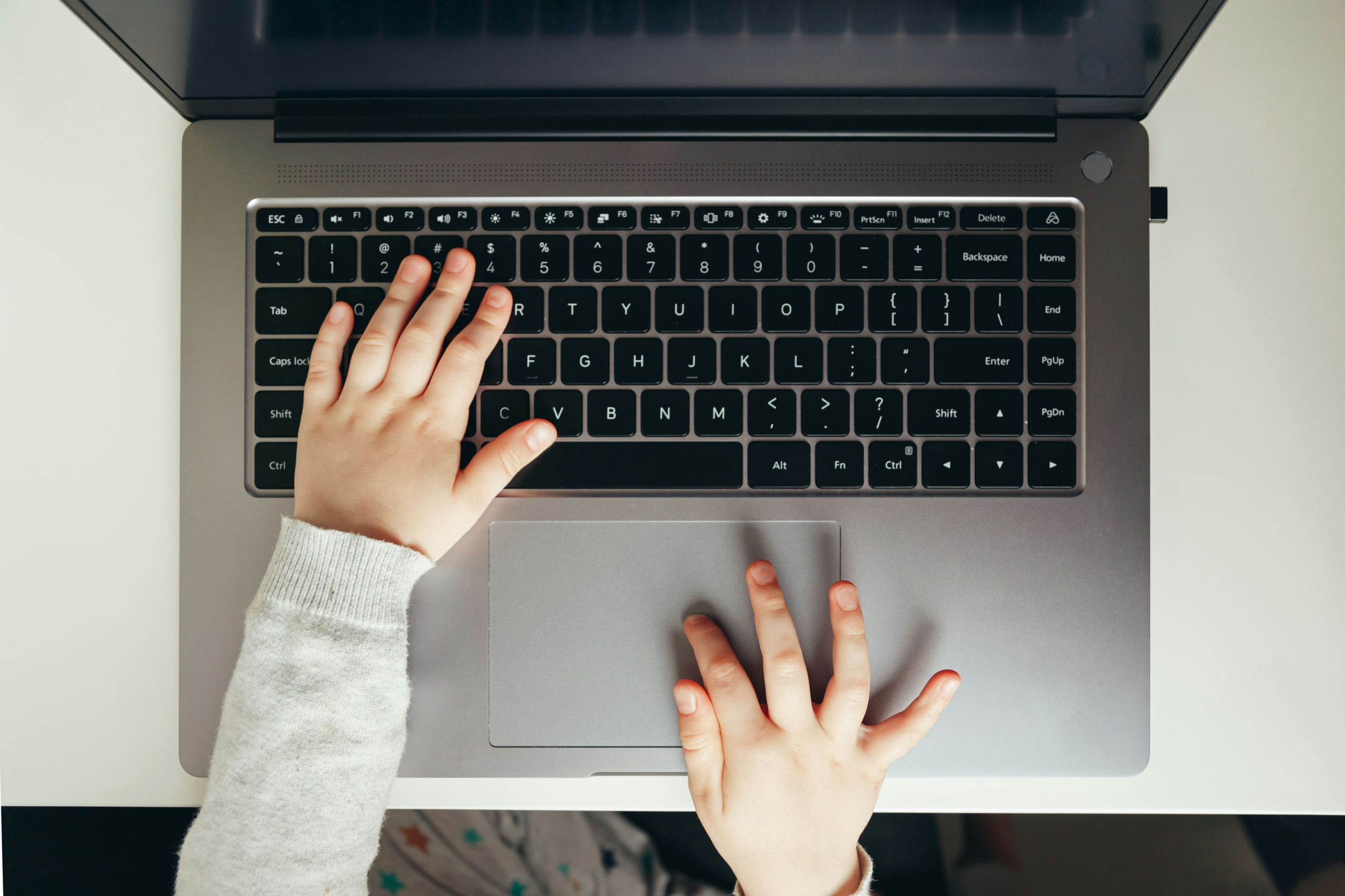 Child's hands on laptop keyboard